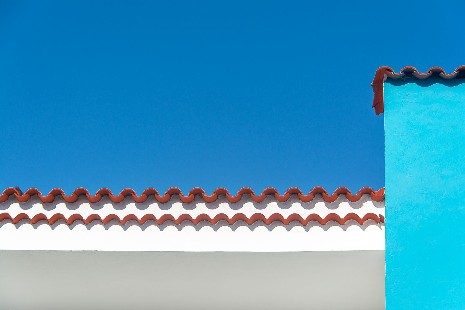 Red clay tile roof against a clear sky